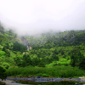 Waterfalls pour down the slopes of Jiaozi Snow Mountain near the park entrance