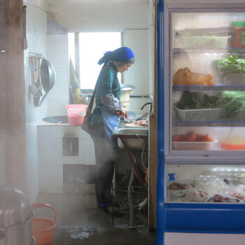 A Hani woman prepares a meal at a local restaurant in Azheke (image credit: Chiara Ferraris)