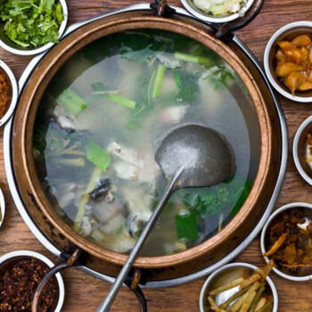 Fuxian Lake fish soup surrounded by condiments